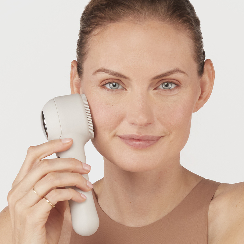 Woman using facial brush